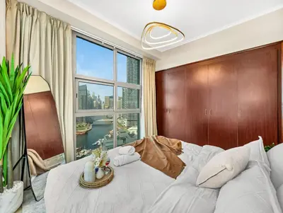 a bedroom with a large white bed with a large window at Luxury 4BR - Full Marina View - High Floor Bliss in Dubai