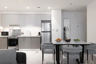 a kitchen with a table with chairs and a refrigerator at FORTE Tower 2 - One-Bedroom Apartment in DOWNTOWN Dubai, near Burj Khalifa & Dubai Fountains - Apartment in Forte Tower 2 in Dubai