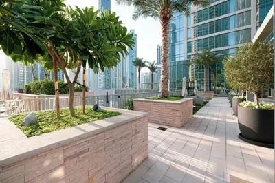 a walkway with palm trees and a building at FORTE Tower 2 - One-Bedroom Apartment in DOWNTOWN Dubai, near Burj Khalifa & Dubai Fountains - Apartment in Forte Tower 2 in Dubai