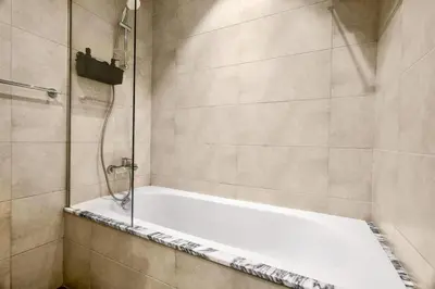 a bathroom with a shower with a white tub at 5 Star Rooftop Infinity Pool with Burj Khalifa Views in Dubai
