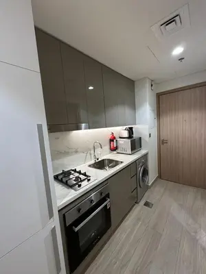 a kitchen with a sink and a stove top oven at Studio Designer Azizi 41 in Dubai