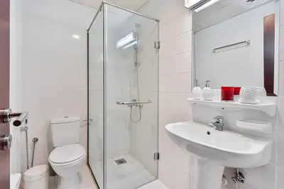 a bathroom with a toilet and a sink and a shower at Spacious 2 BR With Pool, Gym and Kid's Playground in Dubai