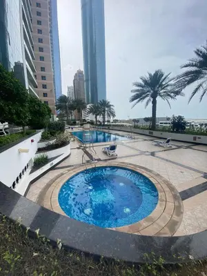 a large swimming pool with palm trees and buildings at Spacious 2 BR With Pool, Gym and Kid's Playground in Dubai