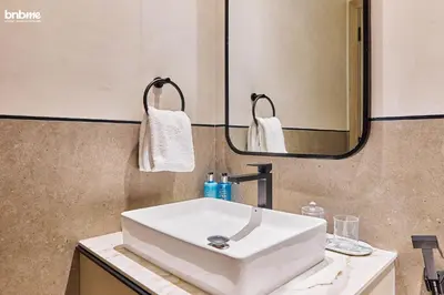a bathroom with a white sink and a mirror at bnbmehomes - Oxford Terraces in Dubai