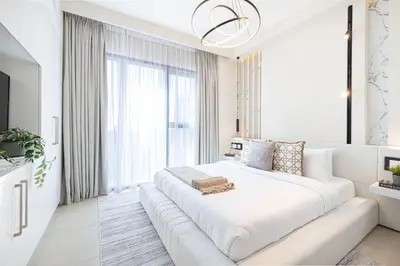 a white bedroom with a large white couch in front of a window at Elite 4 Bedroom Luxury Apartment, Burj Khalifa View, Opposite Dubai Mall, Infinity Swimming Pool in Dubai