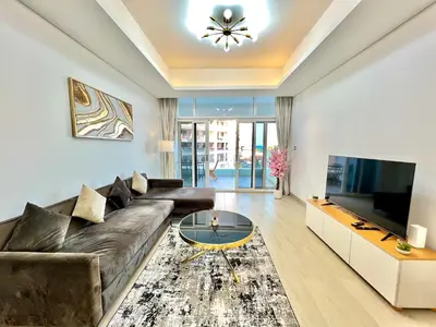 a living room with a couch and a tv at Azizi Mina - Palm Jumeirah in Dubai