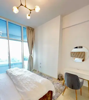 a bedroom with a bed and a desk and window at Azizi Mina - Palm Jumeirah in Dubai