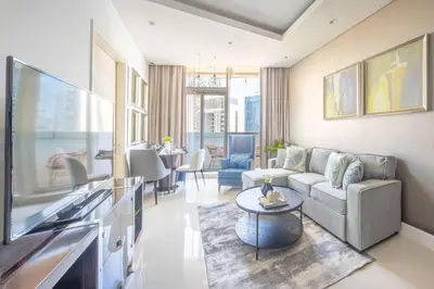 a living room with a couch and a tv at Frank Porter - Damac Distinction in Dubai