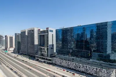a city with tall buildings and a highway with cars at Frank Porter - Damac Distinction in Dubai