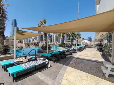 a patio with tables and chairs and a pool at Frank Porter - Damac Distinction in Dubai