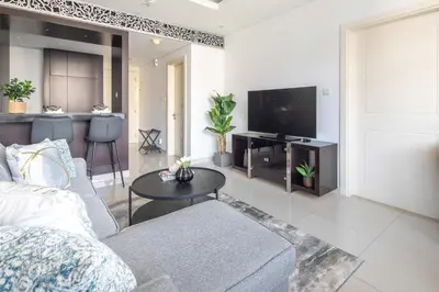 a living room with a couch and a flat screen tv at Frank Porter - Damac Distinction in Dubai
