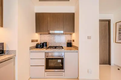 a kitchen with white cabinets and a stove at Gorgeous 1BD Apt with beach access in Grand Bleu in Dubai