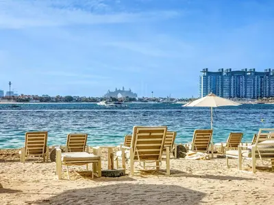 a group of chairs and an umbrella on a beach at Gorgeous 1BD Apt with beach access in Grand Bleu in Dubai