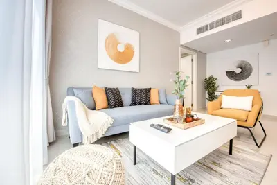 a living room with a blue couch and a coffee table at HAVN - NEW 1 Bedroom Apartment in Business Bay in Dubai