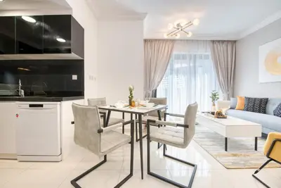 a kitchen and living room with a table and chairs at HAVN - NEW 1 Bedroom Apartment in Business Bay in Dubai