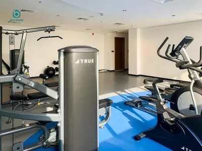 a gym with treadmills and cardio machines at Blue Breeze - Chic & Cozy 1 BR Getaway in Al Furjan in Dubai