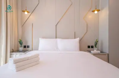 a bedroom with a large white bed with white pillows at Blue Breeze - Chic & Cozy 1 BR Getaway in Al Furjan in Dubai