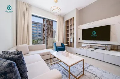 a living room with a couch and a tv at Blue Breeze - Chic & Cozy 1 BR Getaway in Al Furjan in Dubai