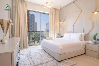 a bedroom with a bed and a large window at Blue Breeze - Chic & Cozy 1 BR Getaway in Al Furjan in Dubai