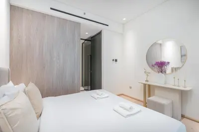 a bedroom with a white bed and a mirror at Elegant 1BHK by CzechIn Luxe Stay with Pool and Gym in Dubai