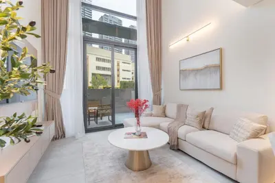 a living room with a white couch and a table at Elegant 1BHK by CzechIn Luxe Stay with Pool and Gym in Dubai