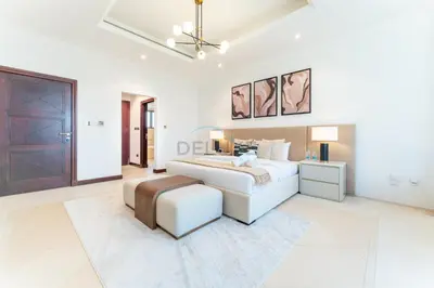 a white bedroom with a bed and a table at Beachfront 6BR and Assistant's Room Villa with Private Pool, Palm Villa, Palm Jumeirah by Deluxe Holiday Homes in Dubai