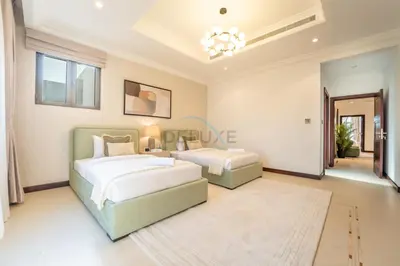 a bedroom with two beds and a chandelier at Beachfront 6BR and Assistant's Room Villa with Private Pool, Palm Villa, Palm Jumeirah by Deluxe Holiday Homes in Dubai