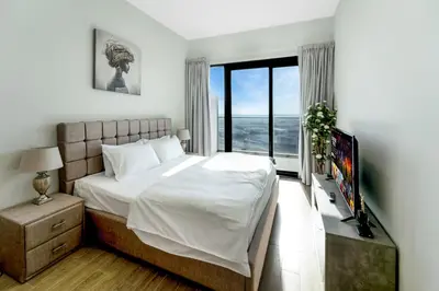 a bedroom with a large bed and a television at Chic 1 BR with Port Views in Dubai