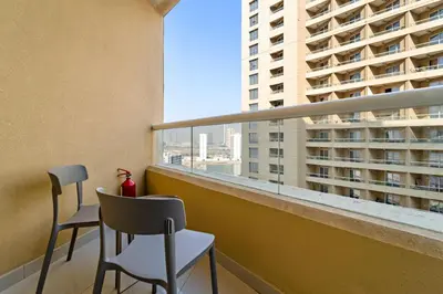 a balcony with two chairs and a view of a building at Modern Studio in Production City in Dubai