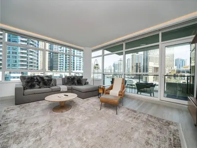 a living room with a couch and a table at Waterfront Dubai Marina 3-Bedroom Sanctuary in Dubai
