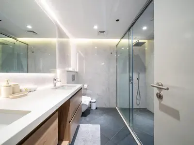 a bathroom with a sink and a glass shower at Waterfront Dubai Marina 3-Bedroom Sanctuary in Dubai