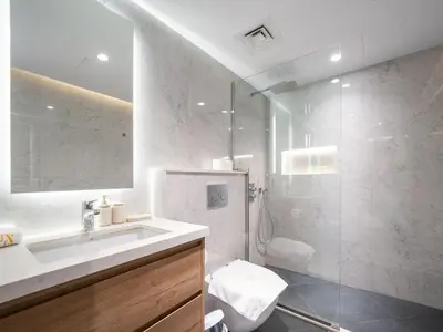 a white bathroom with a sink and a shower at Waterfront Dubai Marina 3-Bedroom Sanctuary in Dubai