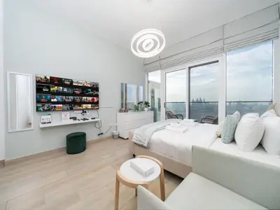 a white bedroom with a large bed and a couch at Elegant Studio in Bloom JVC with High-End Finishes in Dubai