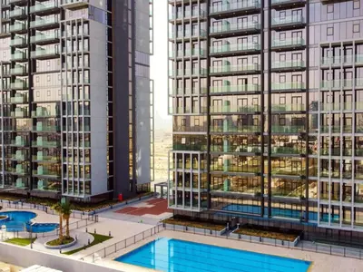 a view of two tall buildings and a swimming pool at Elegant Studio in Bloom JVC with High-End Finishes in Dubai