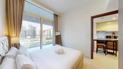 a bedroom with a white bed and a large window at Reva Residences - Cosy One Bedroom in Business Bay in Dubai
