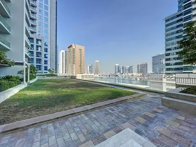 a park in the middle of a city with tall buildings at Reva Residences - Cosy One Bedroom in Business Bay in Dubai