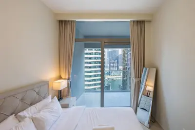 a bedroom with a bed and a large window at Reva Residences - Cosy One Bedroom in Business Bay in Dubai