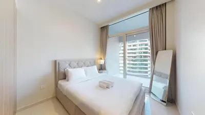 a bedroom with a white bed and a large window at Reva Residences - Cosy One Bedroom in Business Bay in Dubai