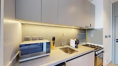 a kitchen with a microwave and a sink at Mag 980 - Cosy Studio with City Views in Meydan in Dubai