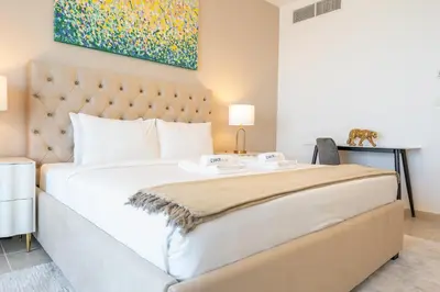 a bedroom with a large bed and a painting at Stylish1BHK in Elite Residences, Marina with View in Dubai