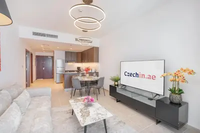 a living room with a couch and a screen at Stylish1BHK in Elite Residences, Marina with View in Dubai