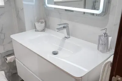a white sink in a bathroom with a mirror at Stylish1BHK in Elite Residences, Marina with View in Dubai