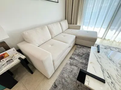 a living room with a white couch and a table at Holiday Homes by DO- The Zumrud in Dubai