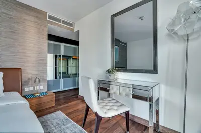 a bedroom with a glass desk and a mirror at GuestReady - Upscale living near Downtown Dubai in Dubai