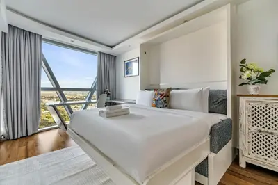 a bedroom with a large white bed and a large window at GuestReady - Upscale living near Downtown Dubai in Dubai