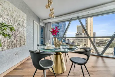 a dining room with a table and chairs and a large window at GuestReady - Upscale living near Downtown Dubai in Dubai