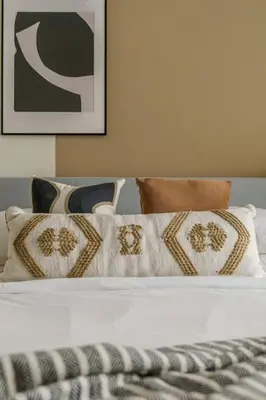 a white bed with pillows and a picture on the wall at GuestReady - Contemporary Apt in JBR in Dubai