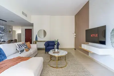 a living room with a white couch and a tv at GuestReady - Contemporary Apt in JBR in Dubai