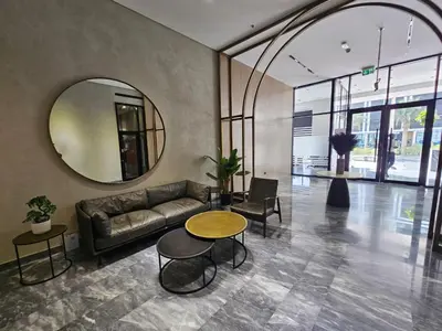 a living room with a couch and a round mirror at Luxury Studio in JVC in Dubai