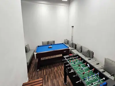 a room with a pool table and chairs at Luxury Studio in JVC in Dubai